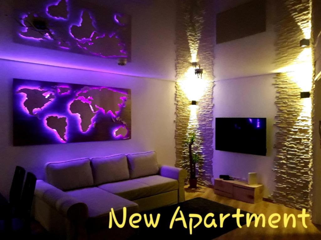salon z fioletowym oświetleniem i kanapą w obiekcie Landmann Apartment Metzingen w mieście Metzingen