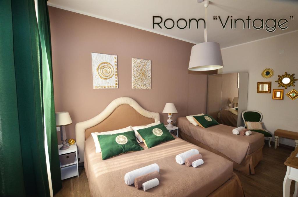 a bedroom with two beds and a room vintage sign at Room & Breakfast Nettuno 29 in Bologna