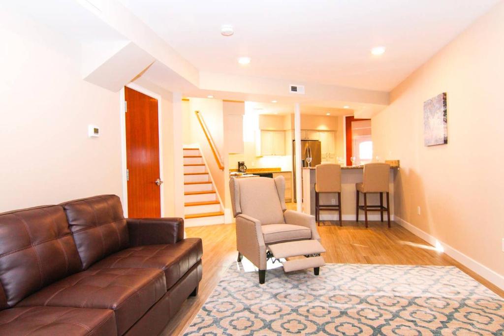 ein Wohnzimmer mit einem braunen Ledersofa und Stühlen in der Unterkunft Luxury 3 Bedroom, 20 min to Boston, 15min Encore in Malden