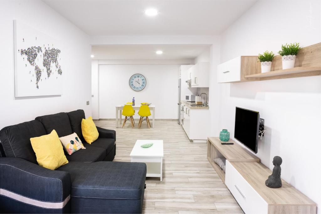 a living room with a couch and a tv at Apartamentos Los Laureles in Los Llanos de Aridane