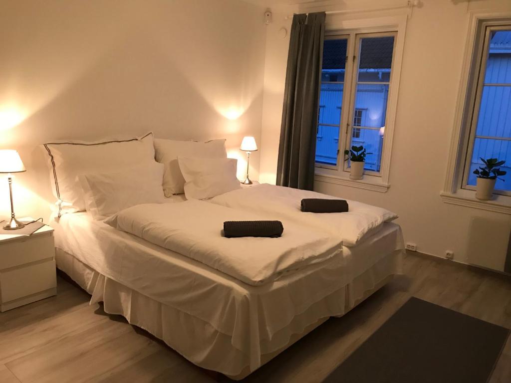 a bedroom with a large white bed with two pillows at A Noi Rooms in Kragerø