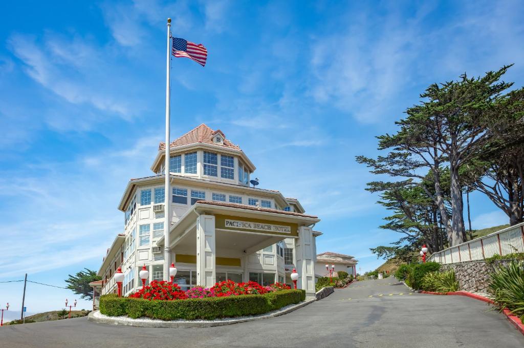 Un edificio con una bandiera americana sopra. di Pacifica Beach Hotel a Pacifica
