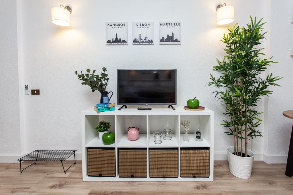 A television and/or entertainment centre at Spectacular Renovated Apartment, 5 min to Camison Beach, with AirCon