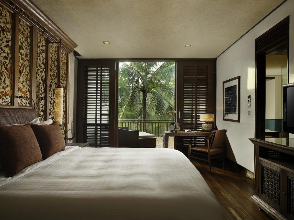 a bedroom with a bed and a window and a desk at Four Seasons Resort Bali at Sayan in Ubud