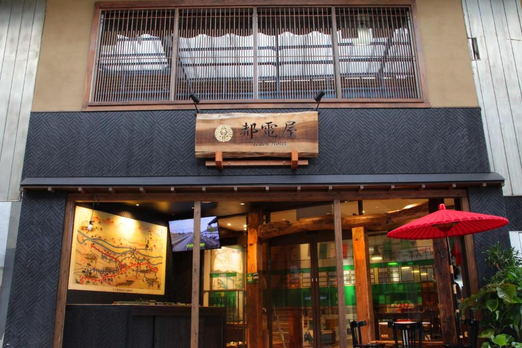 un restaurante con una sombrilla roja delante de él en 都電屋 TodenHotel, en Tokio