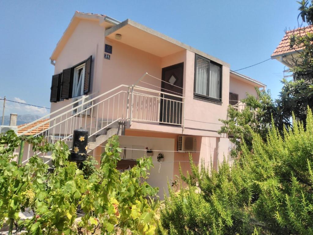 a house with a balcony and some trees at Holiday home Boris - close to sea in Slatine