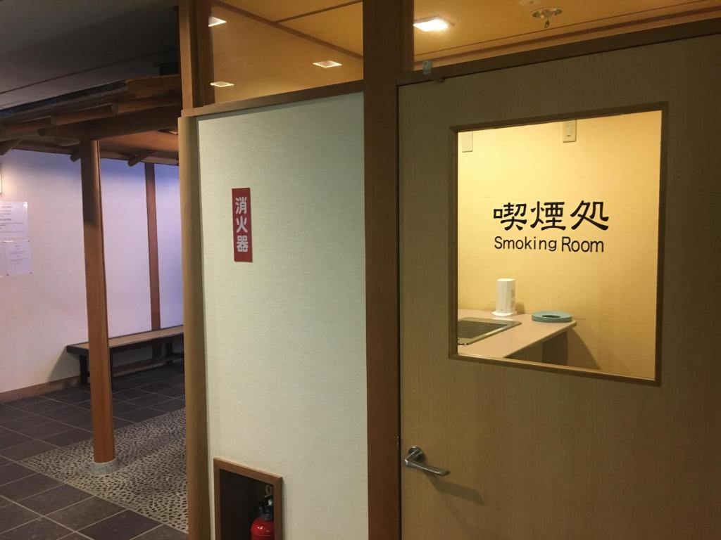 a door to a smoking room with a sign on it at Miyajima Morinoyado in Miyajima