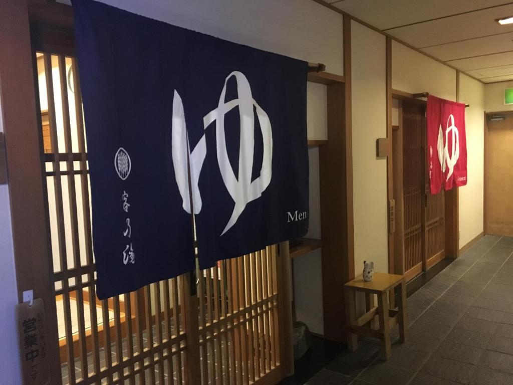 a blue and white flag hanging on a fence at Miyajima Morinoyado in Miyajima
