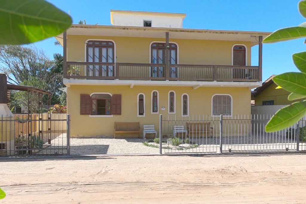 una casa amarilla con una valla delante de ella en Casa Temporada, en Florianópolis
