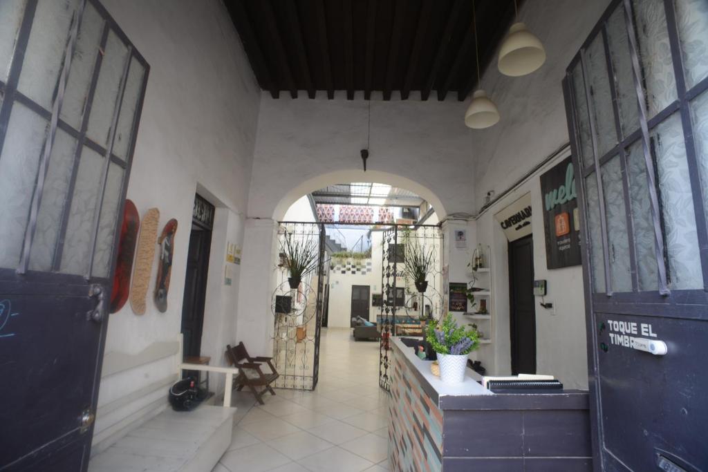 un pasillo de un edificio con una puerta abierta en El Petate Hostel, en Querétaro