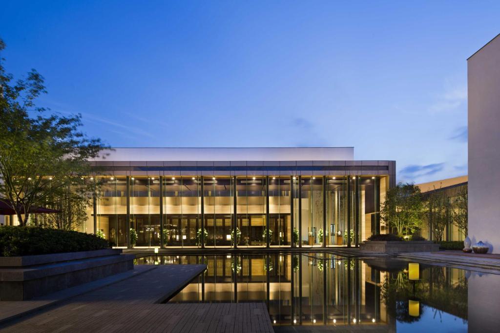 a large building with a pool in front of it at CITIC Pacific Zhujiajiao Jin Jiang Hotel in Qingpu