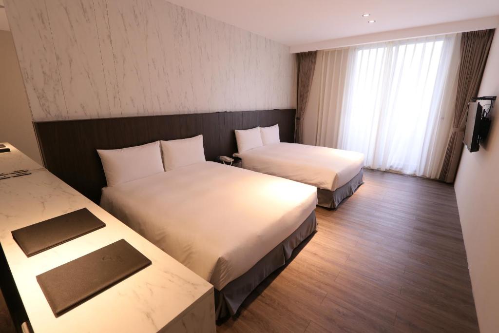 Postel nebo postele na pokoji v ubytování Hotel Hesper HSR Taichung