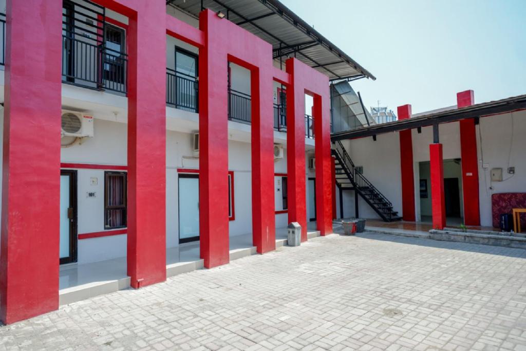 un edificio con columnas rojas en un patio en RedDoorz Syariah near Alun Alun Tegal en Tegal