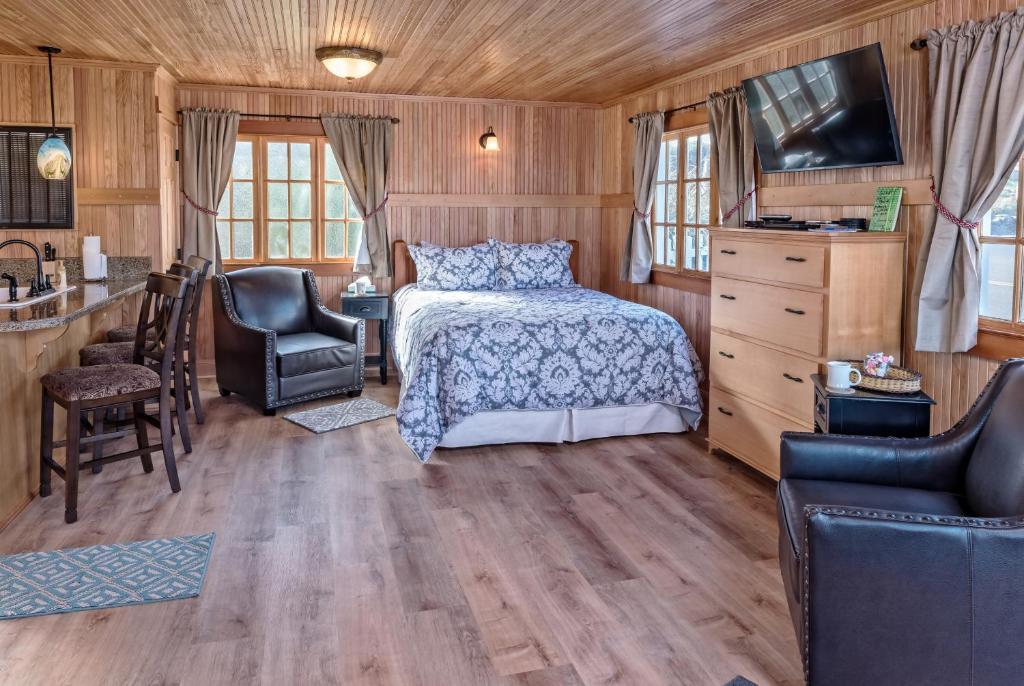 林肯市的住宿－Whistling Winds Motel，一间卧室配有一张床和两把椅子