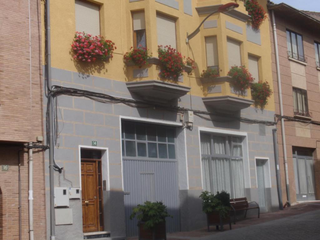 un edificio con cajas de flores en su lado en Pensión Arroniz, en Arróniz
