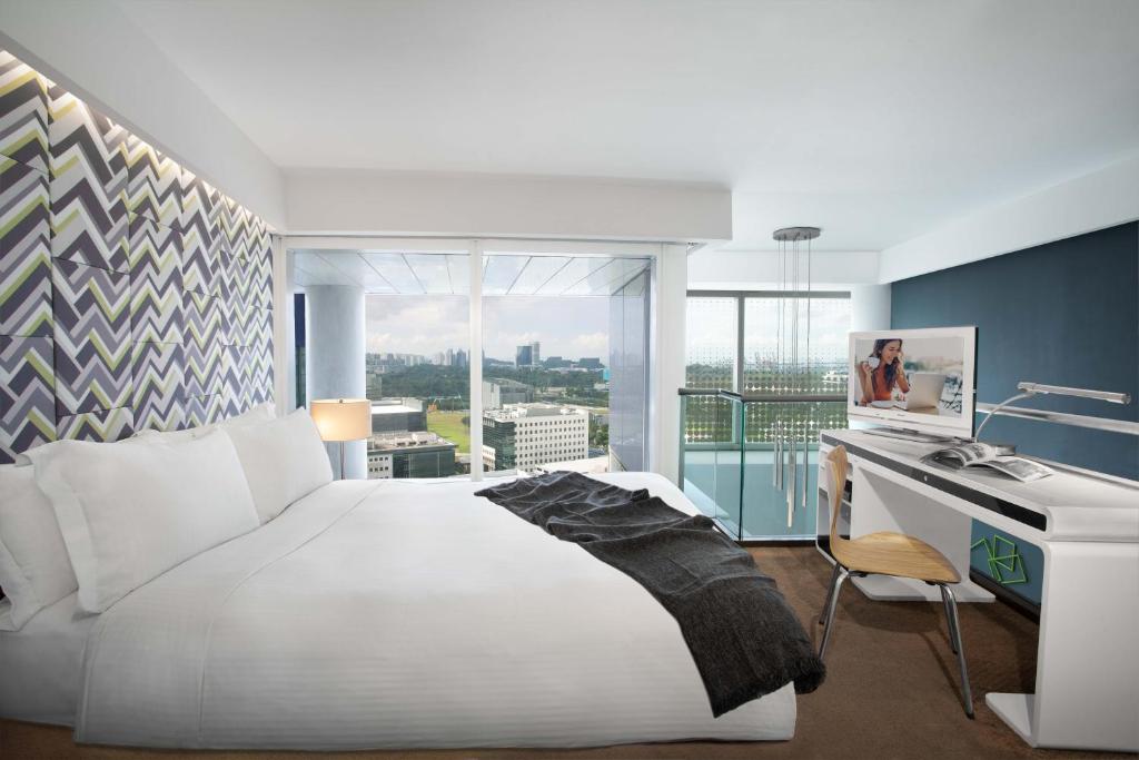 a hotel room with a bed and a tv at Citadines Fusionopolis Singapore in Singapore