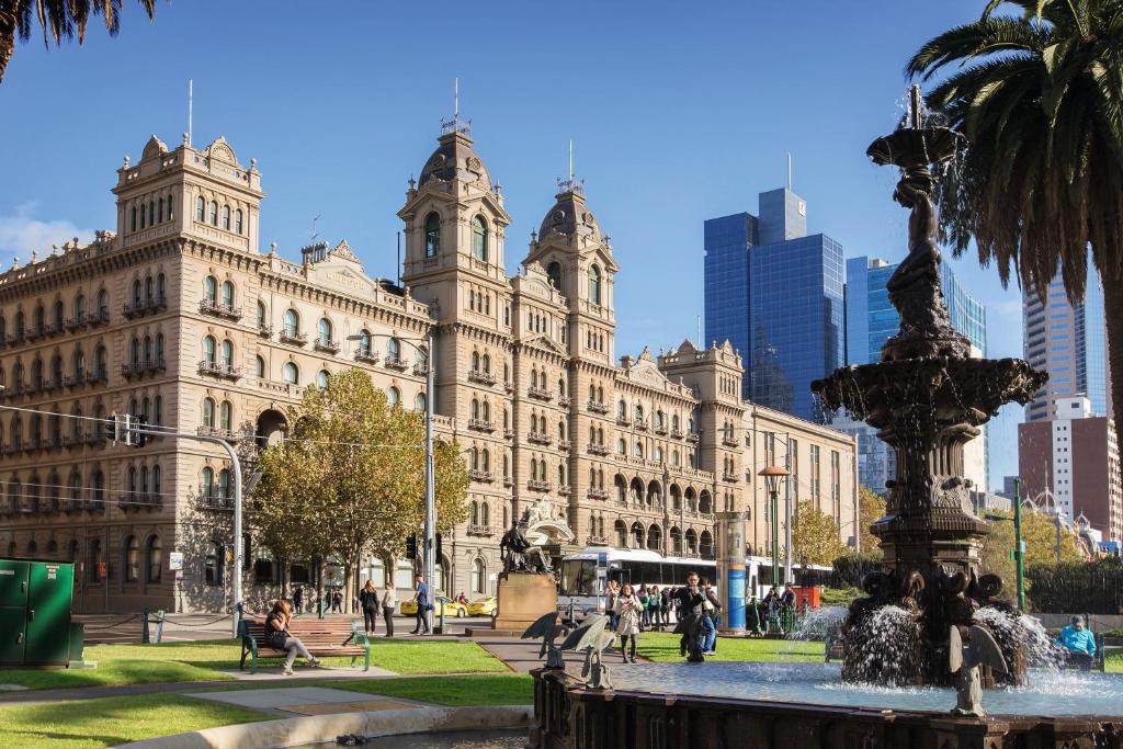 um grande edifício com uma fonte em frente em The Hotel Windsor em Melbourne