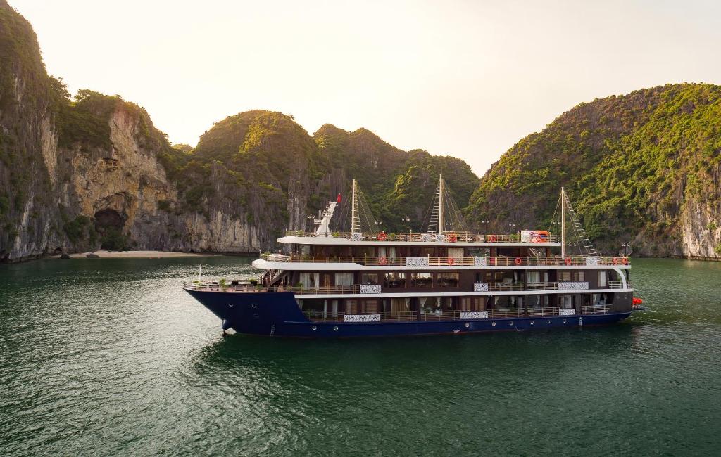 a cruise ship in the water near some cliffs at La Pandora Cruises in Ha Long