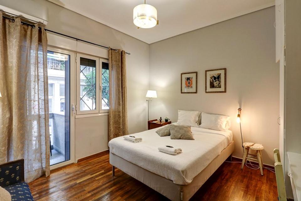 um quarto com uma cama grande e uma janela em Victoria Jewels em Atenas