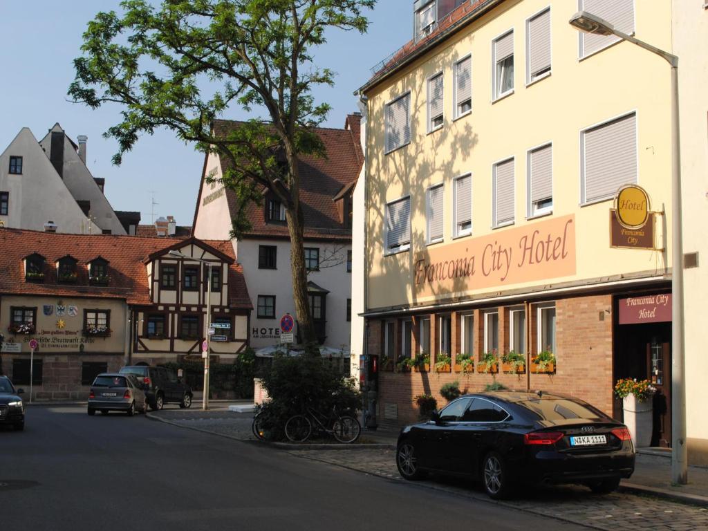 ein schwarzes Auto, das vor einem Gebäude parkt in der Unterkunft Franconia City Hotel in Nürnberg