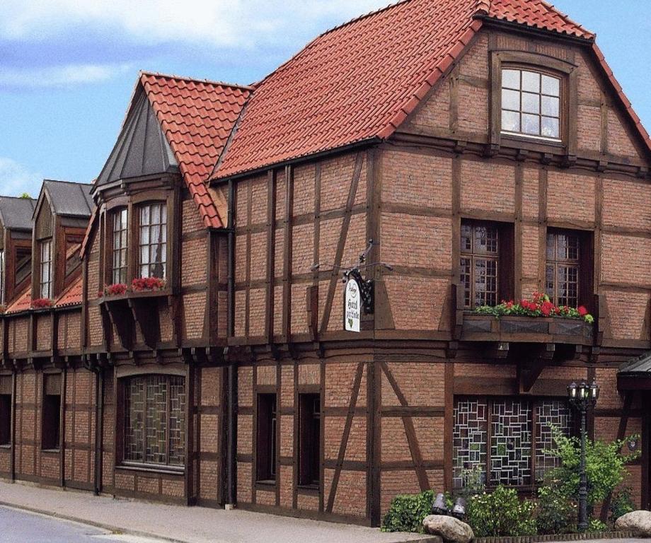 un edificio antiguo con techo rojo en Hotel Restaurant zur Linde, en Pattensen