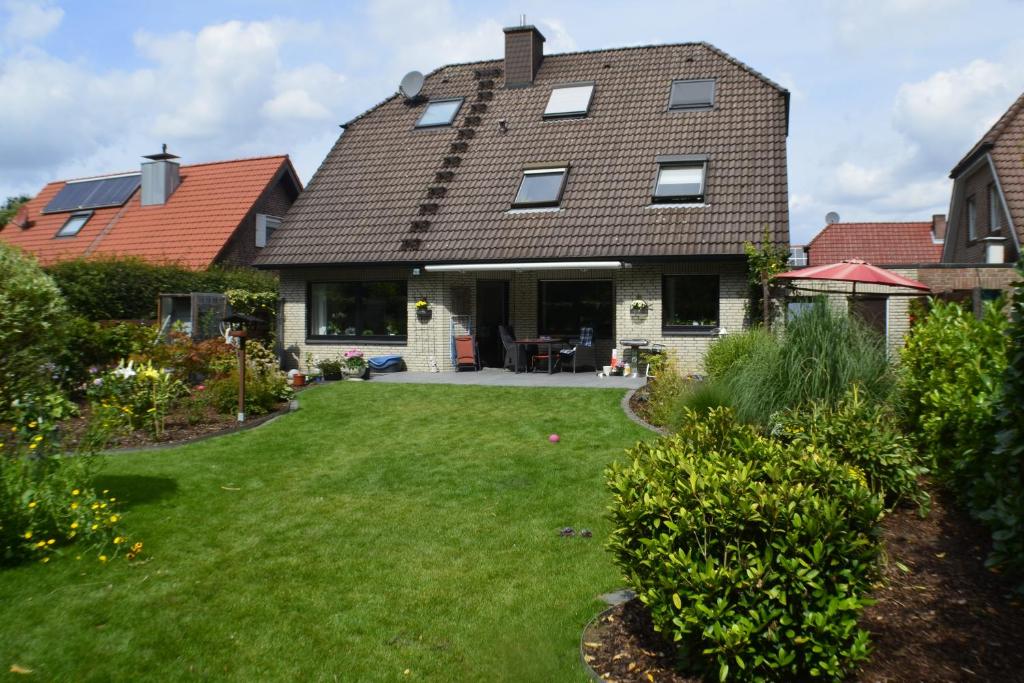 uma casa com um relvado verde em frente em Ferienwohnung Tiberquelle em Dülmen