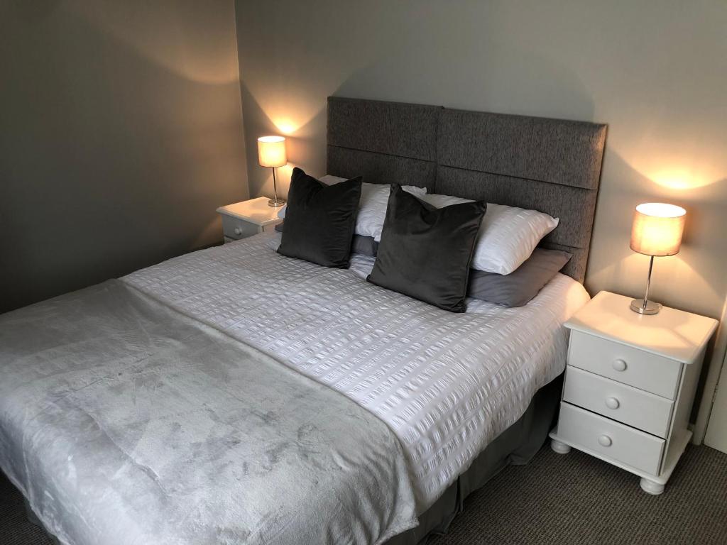 1 dormitorio con 1 cama grande y 2 mesitas de noche en 34 Brunton Street Serviced Accommodation, en Darlington
