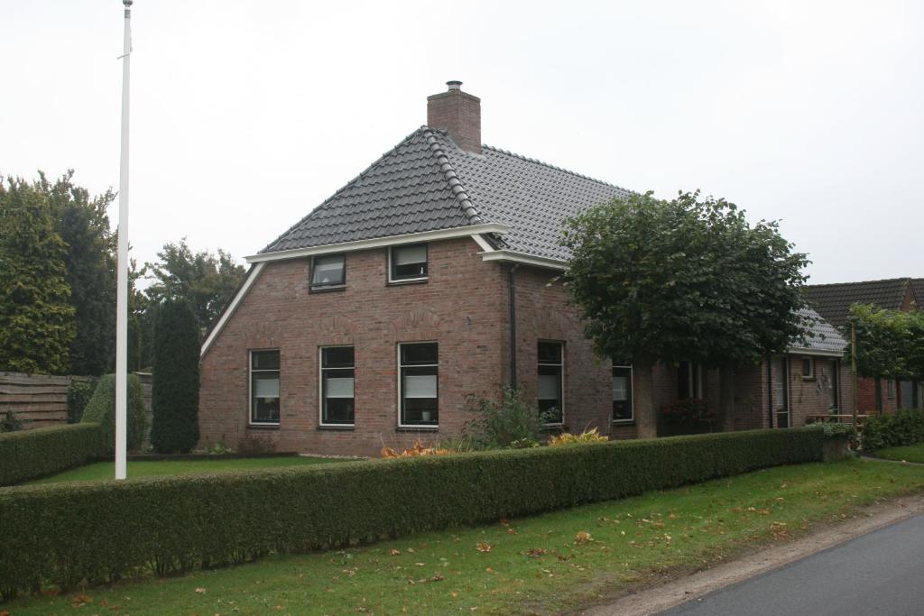 een stenen huis met een zwart dak op een straat bij De Pompstee Rolde in Rolde