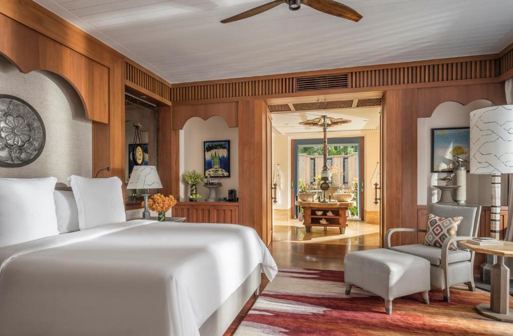 a bedroom with a bed and a living room at Four Seasons Resort Langkawi in Tanjung Rhu