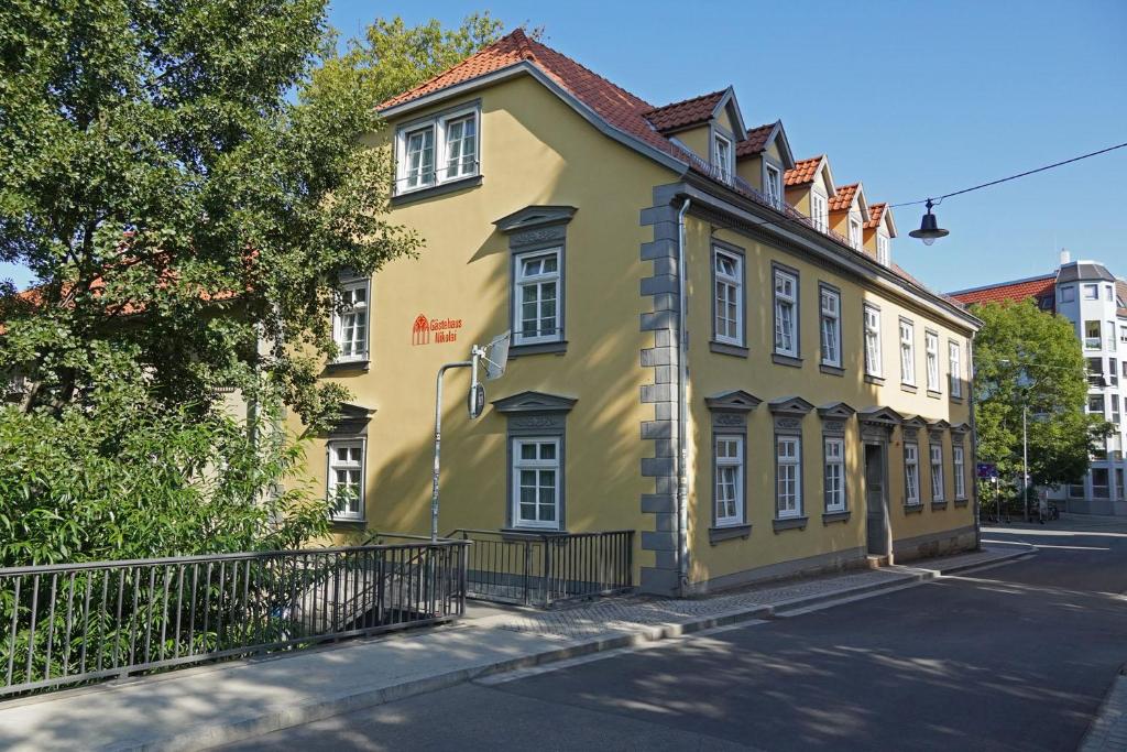 a yellow building on the side of a street at Gästehaus Nikolai in Erfurt