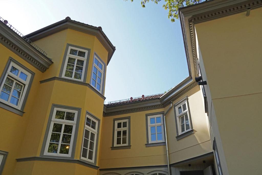un edificio giallo con finestre bianche su una strada di Gästehaus Nikolai a Erfurt