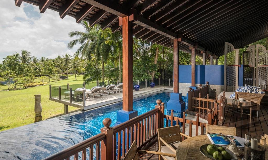 a pool at a resort with a table and chairs at Four Seasons Resort Langkawi in Tanjung Rhu