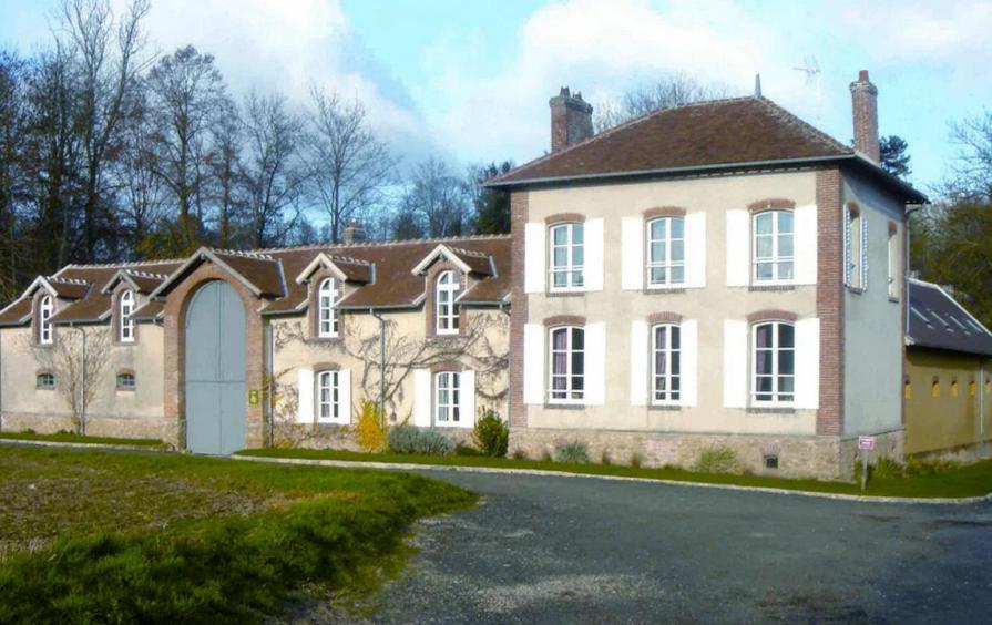 een groot bakstenen huis met een oprit bij Gîte du Domaine du Ru in Aulnoy