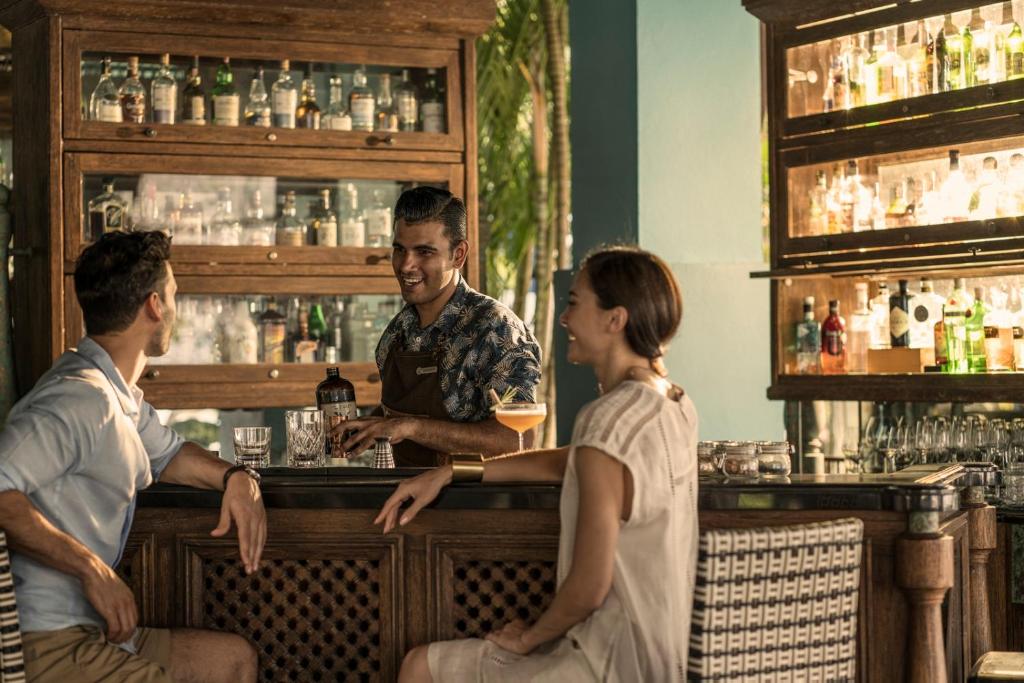a group of people sitting at a bar at Four Seasons Resort Langkawi in Tanjung Rhu