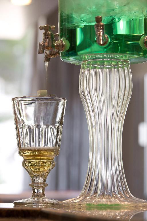 a glass vase and a glass cup on a table at The Originals Boutique, Hôtel Les Strélitzias in Juan-les-Pins
