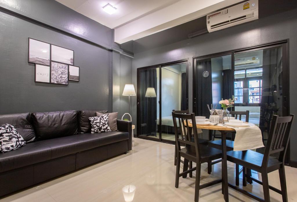 T5 2 Bedrooms/6guests/full kitchen/1 min to BTS في بانكوك: غرفة معيشة مع أريكة وطاولة