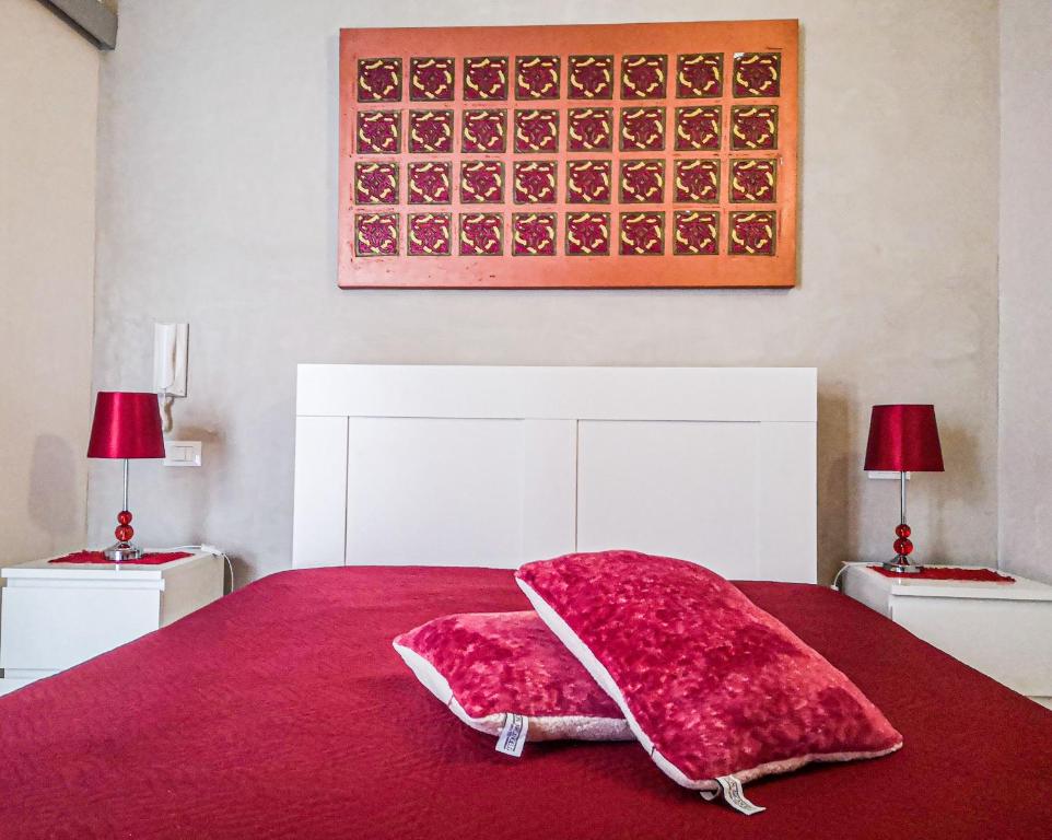 a bed with a red blanket on top of it at Casaulente in Alcamo
