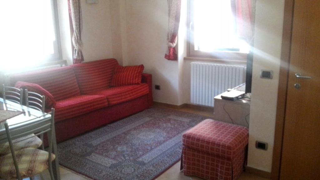 sala de estar con sofá rojo y ventanas en Casa Laura en Valdidentro