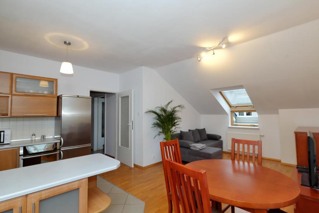 een keuken en een woonkamer met een houten tafel en een eetkamer bij Apartament Słoneczny 2 in Opole