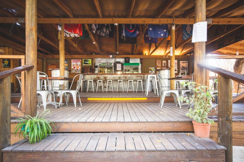un restaurante con sillas blancas y un bar en Sitatunga Campsite Maun, en Maun