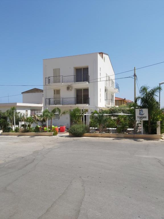 an empty parking lot in front of a white building at Mountains View in Castellammare del Golfo