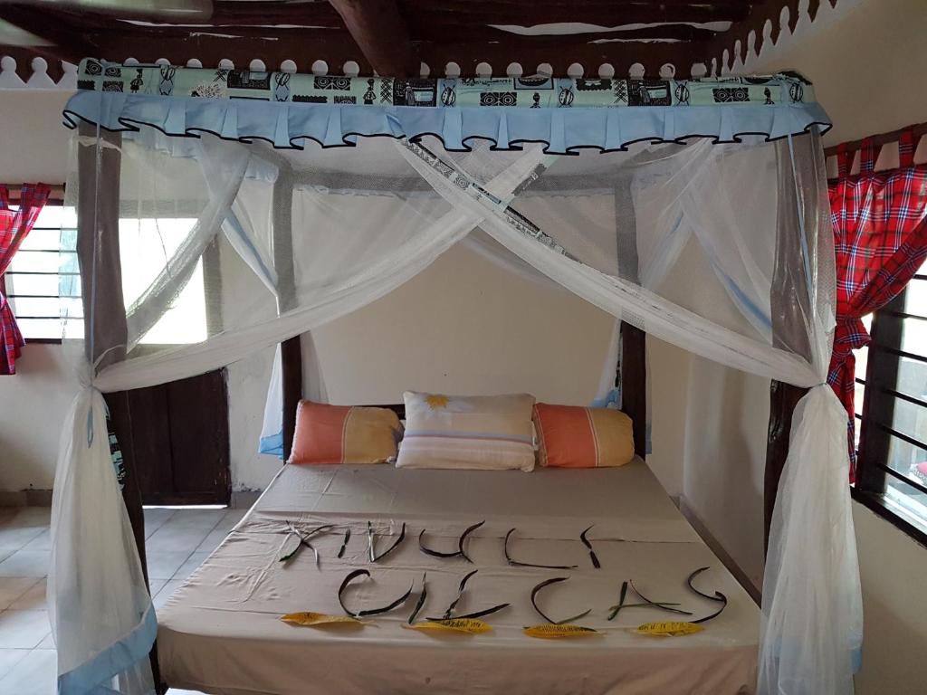 A wonderful Beach property in Diani Beach Kenya.a dream holiday place. في مومباسا: سرير مع مظلة في الغرفة
