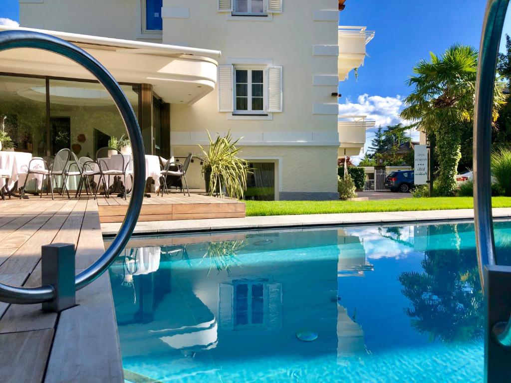 a swimming pool in front of a house at Hotel Villa Freiheim in Merano