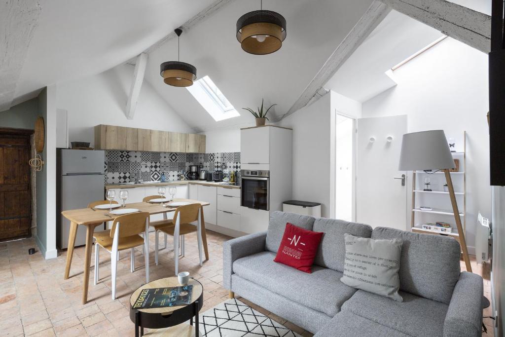 un salon avec un canapé et une table dans l'établissement Le Nao- L'Île Feydeau - 2 chambres de charme, à Nantes