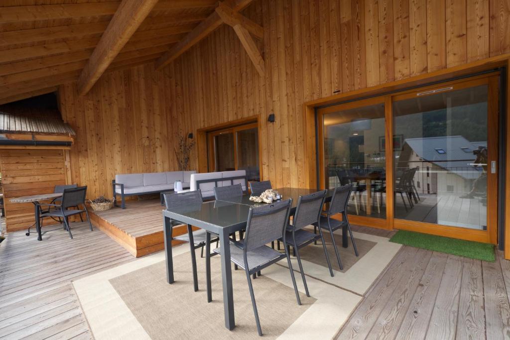 a dining room with a table and chairs on a deck at L'Eyssaben Appartement de grand standing à Serre-Chevalier in Le Monêtier-les-Bains