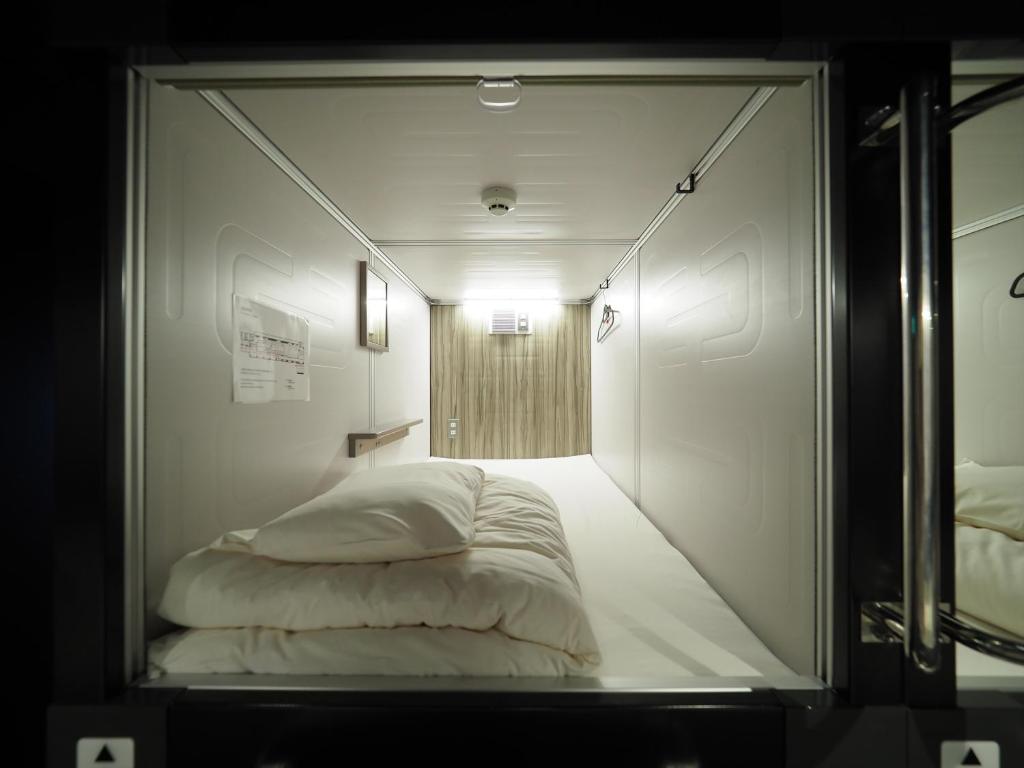 Postel nebo postele na pokoji v ubytování LEO YU Capsule Hotel Nishifunabashi