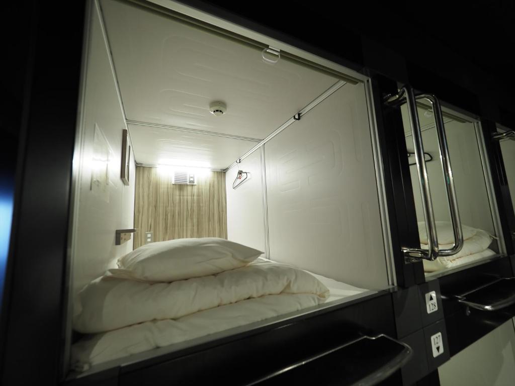 Postel nebo postele na pokoji v ubytování LEO YU Capsule Hotel Nishifunabashi