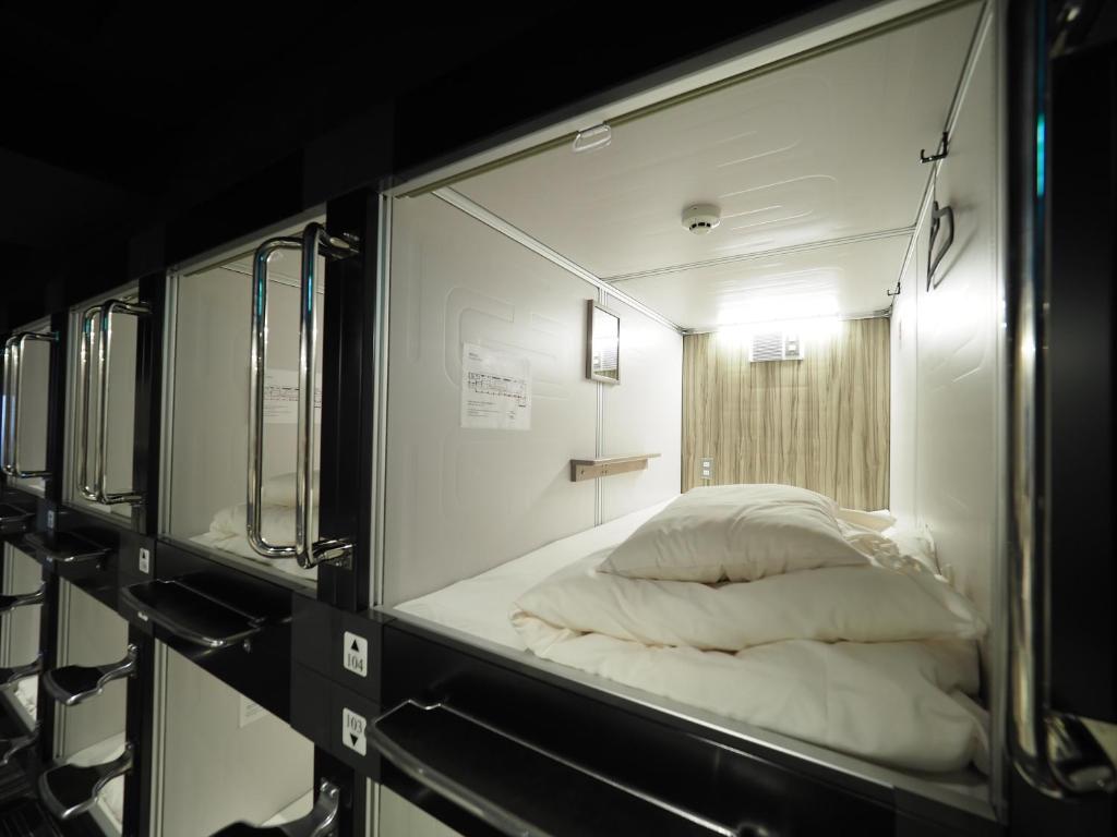 Postel nebo postele na pokoji v ubytování LEO YU Capsule Hotel Nishifunabashi