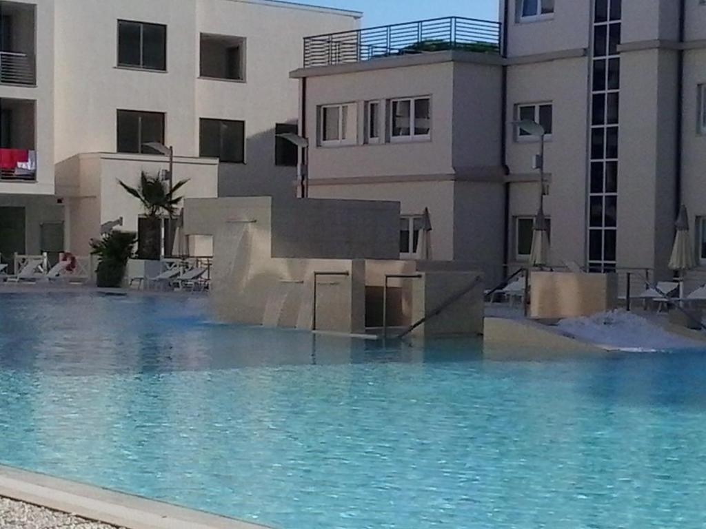 a large swimming pool in front of a building at Hotel Terme Marine Leopoldo II TERME & SPA in Marina di Grosseto