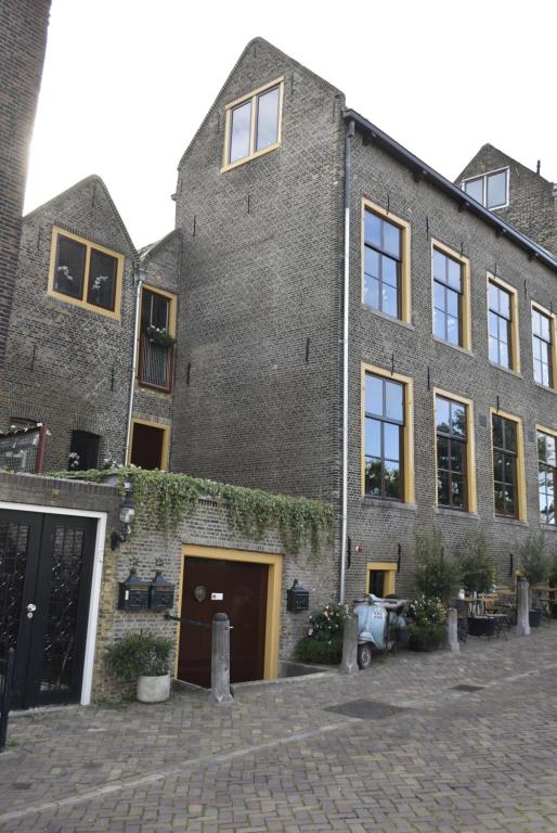 un gran edificio de ladrillo con ventanas y hiedra. en B&B de Gusto, en Schiedam